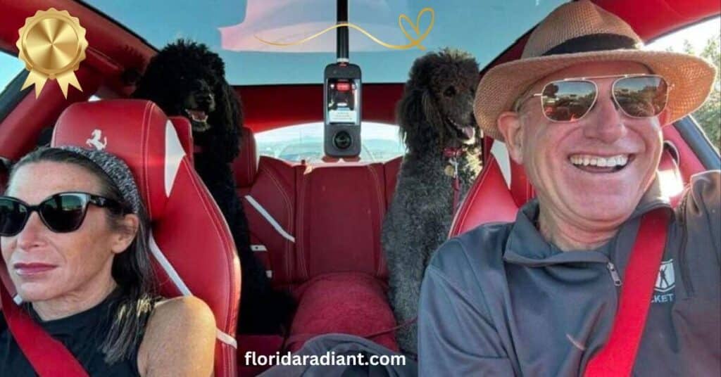 A man and woman are in a car with two dogs, creating a warm and cheerful atmosphere during their drive.