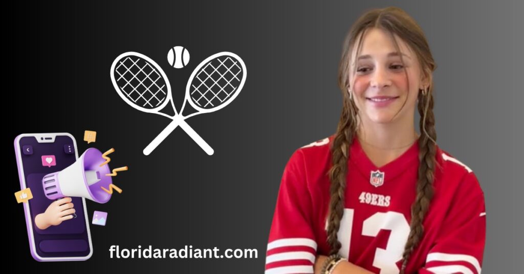 A girl with braided hair grips a tennis racket while holding a cell phone, poised for action on the court.