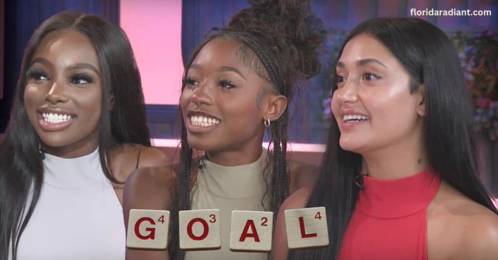 Three joyful women displaying the word "goal," showcasing teamwork and positivity in their expressions.