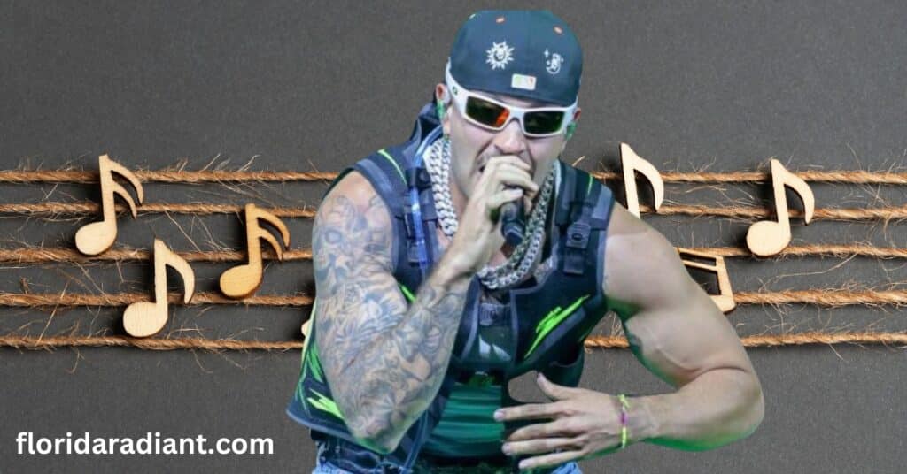 A tattooed man wearing sunglasses passionately sings into a microphone, showcasing his vibrant personality and musical talent.