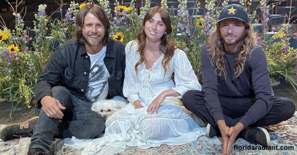 Three individuals seated on a rug, enjoying each other's company alongside a friendly dog.