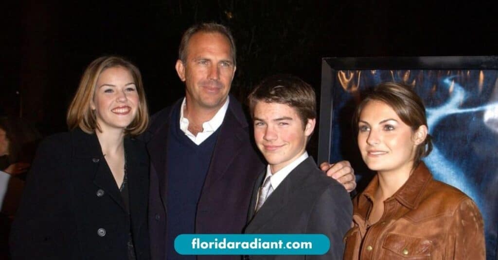 A family smiles together for a photo at a movie premiere, capturing a moment of joy and celebration.