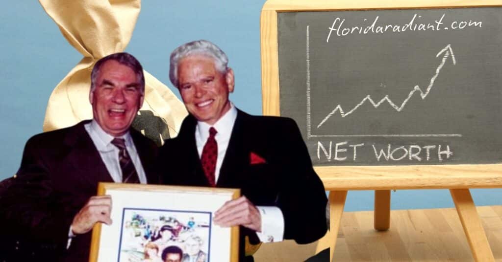 Two men display a blackboard featuring an image of another man holding a net worth chart, illustrating financial growth.