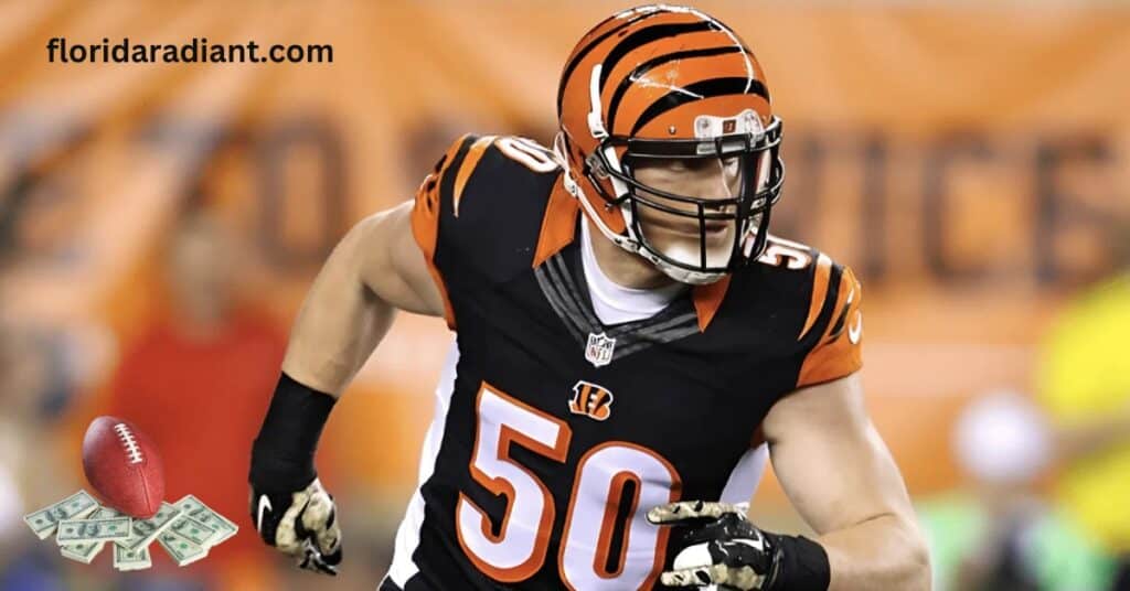 A football player in a black and orange uniform stands confidently, holding a football in preparation for the game.